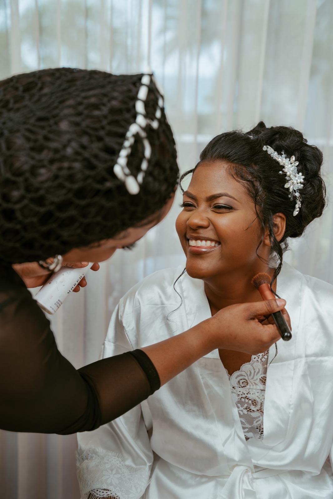 Amesha laughing as she gets her makeup done